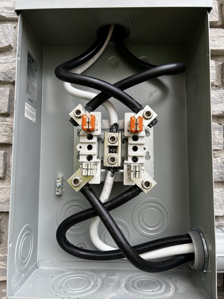 Close-up of wiring and terminals inside an electrical meter base