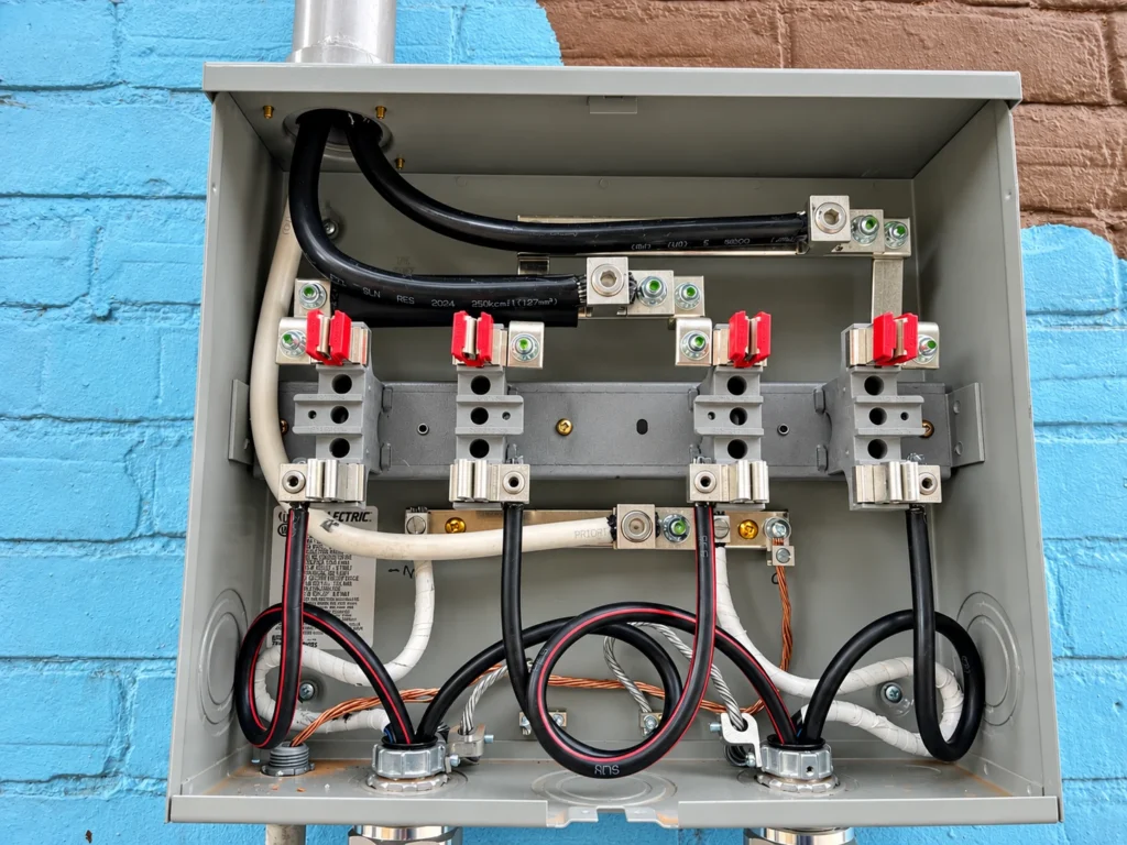 Close-up of the conductors, terminals and connections inside an open dual meter enclosure
