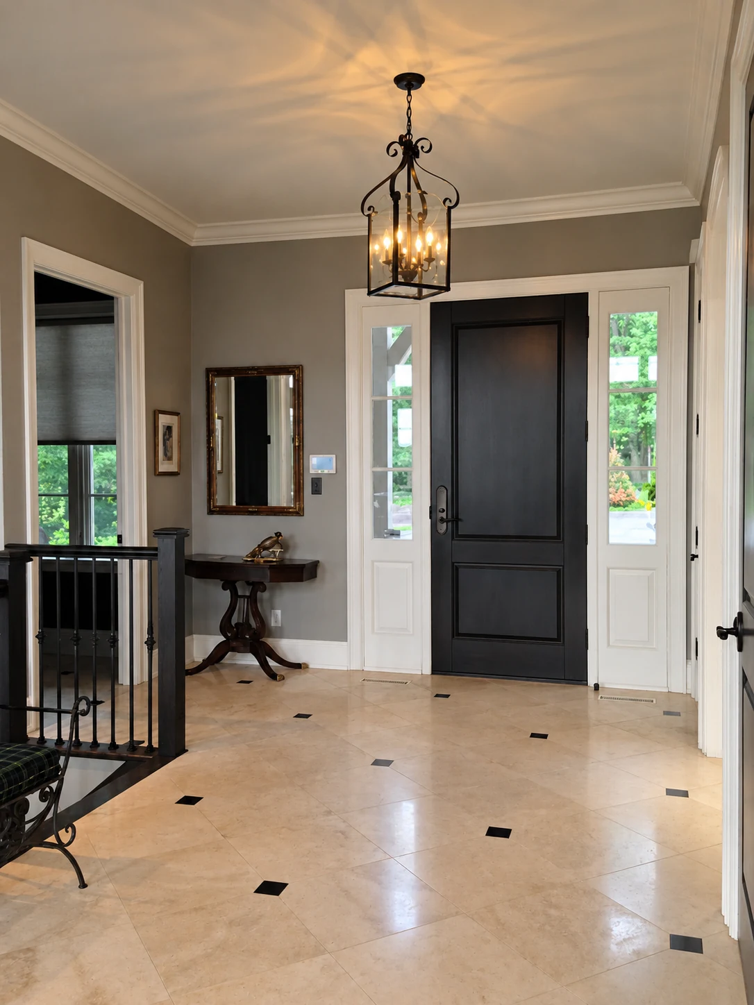 Illuminated lantern chandelier above a tiled entryway with a dark front door