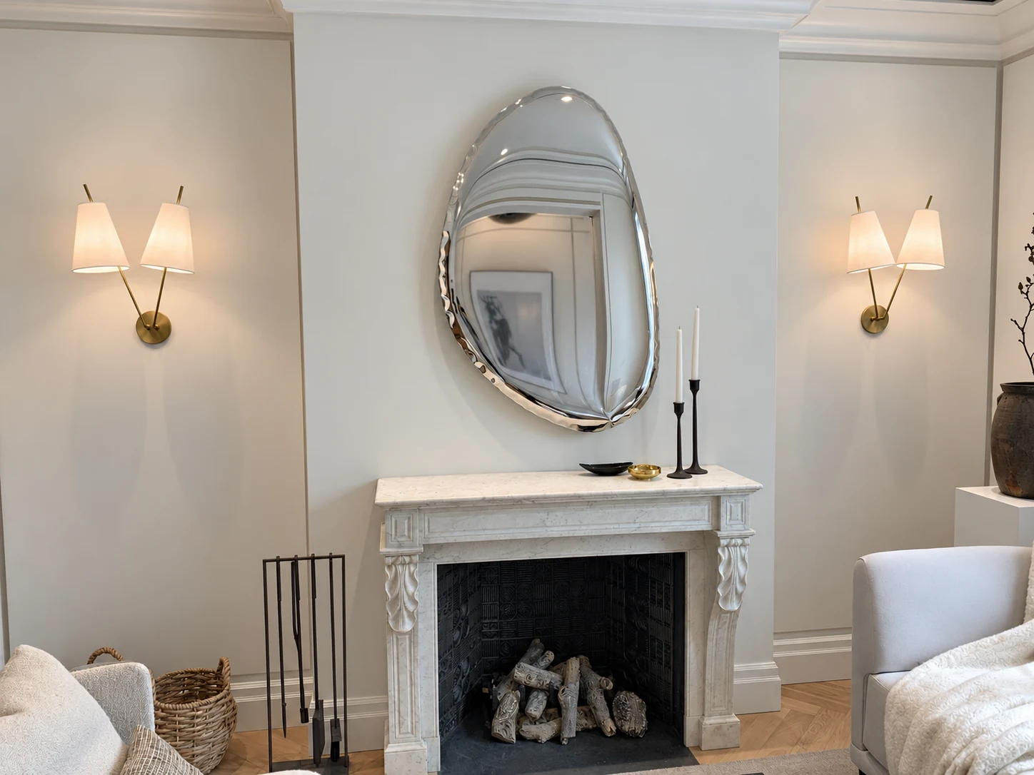 Pair of double-shade brass wall sconces flanking a mirror above a marble fireplace