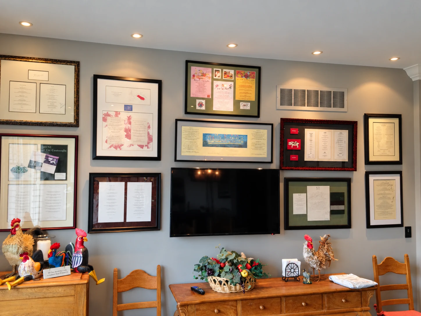 Recessed accent lights illuminating framed displays around a wall-mounted television