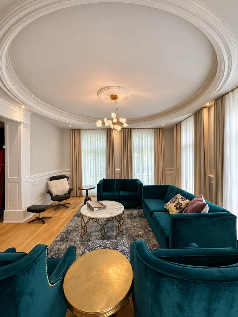 Living room with a floral glass chandelier, recessed perimeter lights and a circular ceiling detail